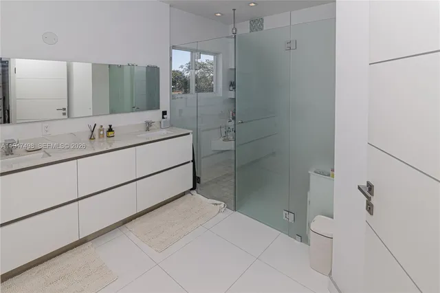 a bathroom with a double vanity sink toilet and shower