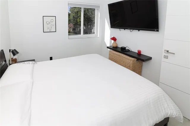 a bedroom with a bed and a flat screen tv