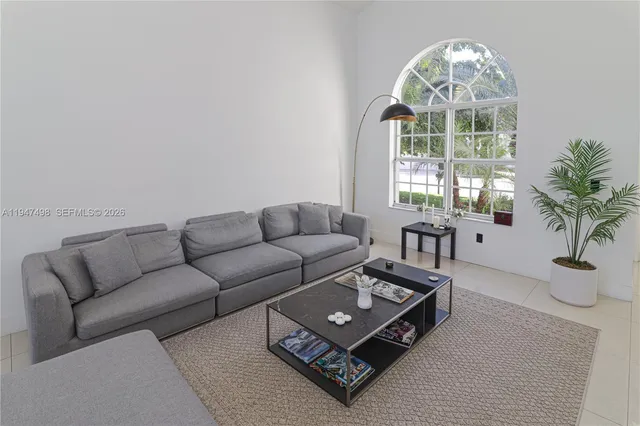 a living room with furniture a table and a large window