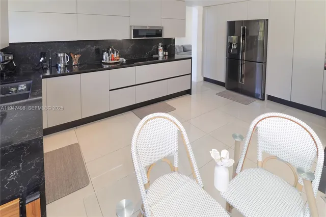 a kitchen with stainless steel appliances granite countertop a refrigerator and microwave