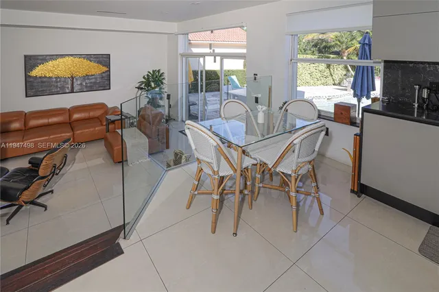 a dining room with furniture and a floor to ceiling window