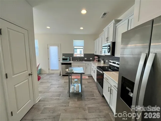 a kitchen with stainless steel appliances a refrigerator and a stove
