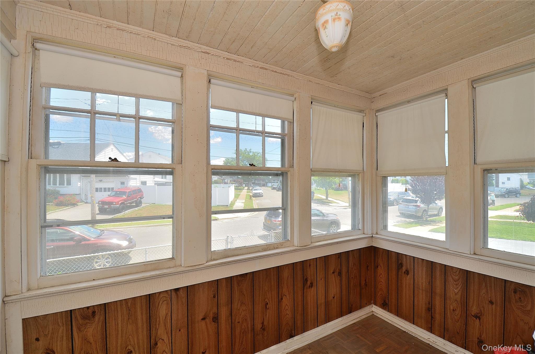 2586 Riverside Drive Wantagh, NY 11793 - Photo 5 of 28 Entry featuring multiple windows with roller shades, wood-finish flooring, and horizontal wood paneling