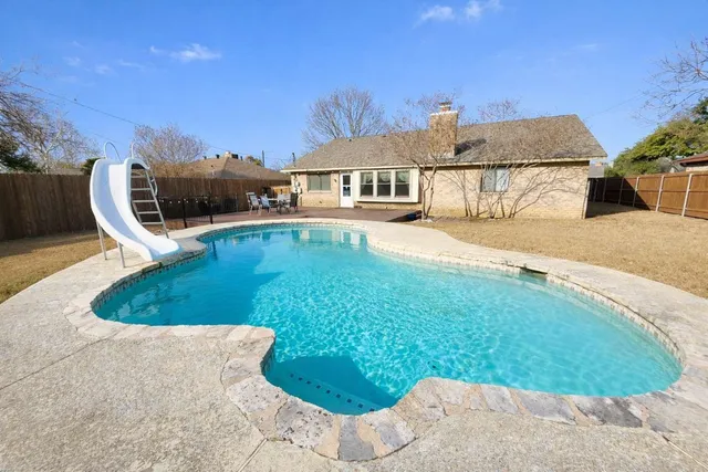 a view of a house with swimming pool and sitting area