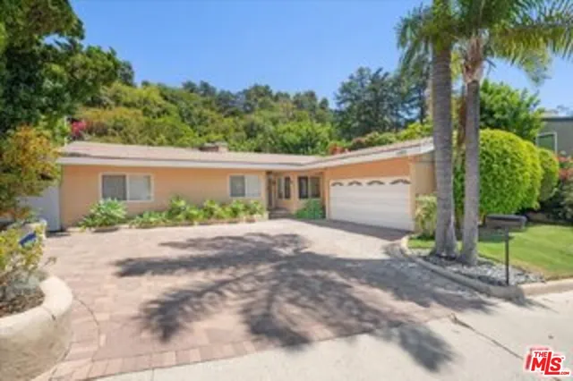 a view of a house with a yard and potted plants