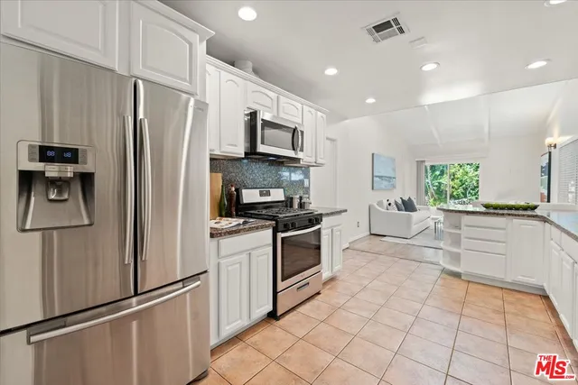 a kitchen with stainless steel appliances a refrigerator sink and microwave