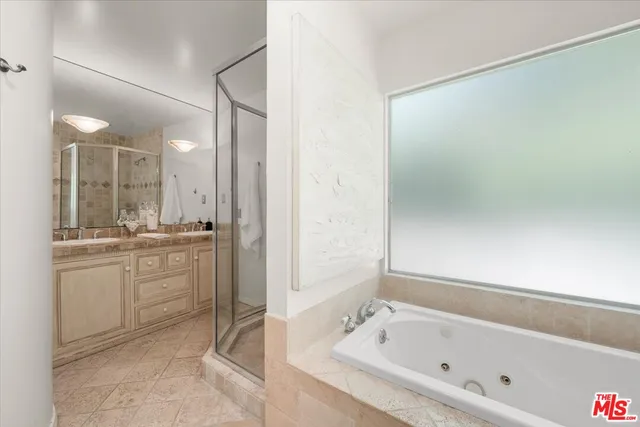 a bathroom with a tub sink and mirror