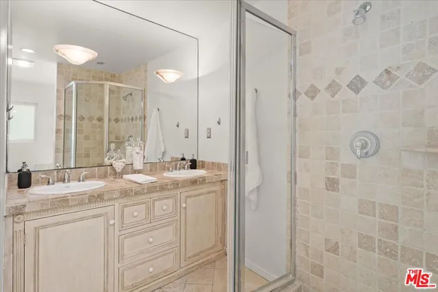 a bathroom with a double vanity sink mirror and shower