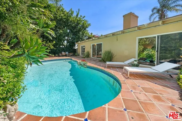 a swimming pool with outdoor seating and yard