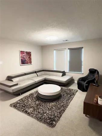 a living room with furniture a rug and a window
