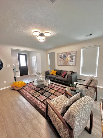 a living room with furniture a rug and a window