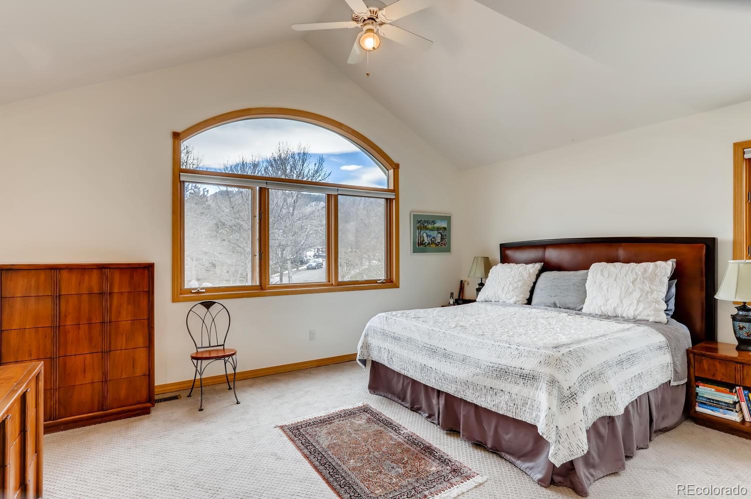 1450 Oakleaf Circle Boulder, CO 80304 - Photo 12 of 27 a bedroom with a large bed and a chandelier