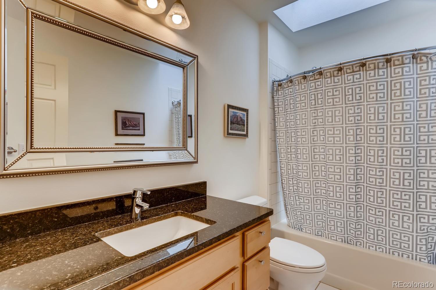 1450 Oakleaf Circle Boulder, CO 80304 - Photo 19 of 27 a bathroom with a sink a toilet a mirror and shower