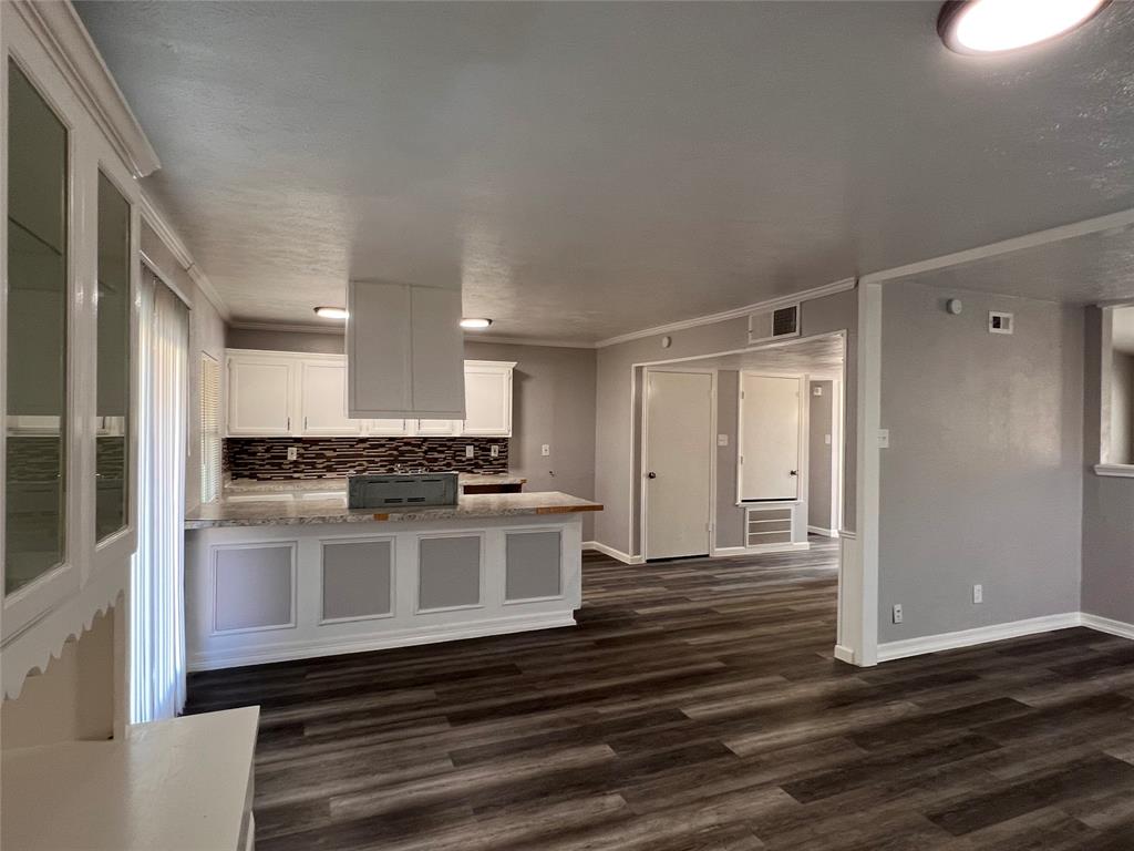 8506 Woodside Road Rowlett, TX 75088 - Photo 16 of 25 a kitchen with kitchen island granite countertop a sink cabinets and wooden floor