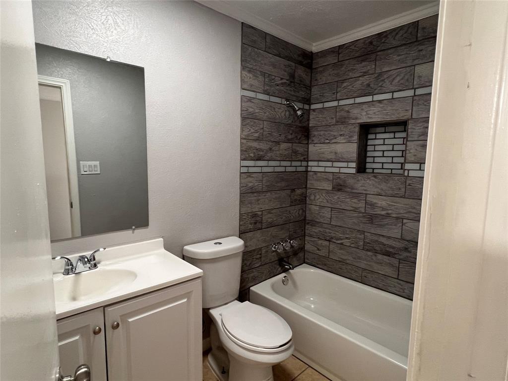 8506 Woodside Road Rowlett, TX 75088 - Photo 19 of 25 a bathroom with a toilet a sink and shower