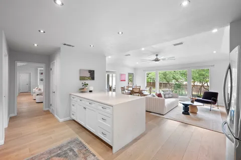 a large white kitchen with a large window and furniture