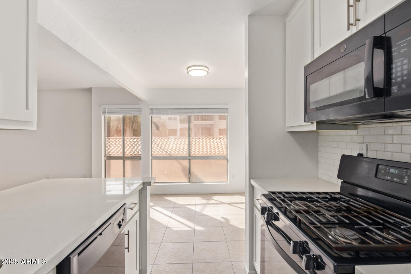 1701 West Tuckey Lane, Unit 231 Phoenix, AZ 85015 - Photo 13 of 17 a kitchen with granite countertop a stove and a white cabinets