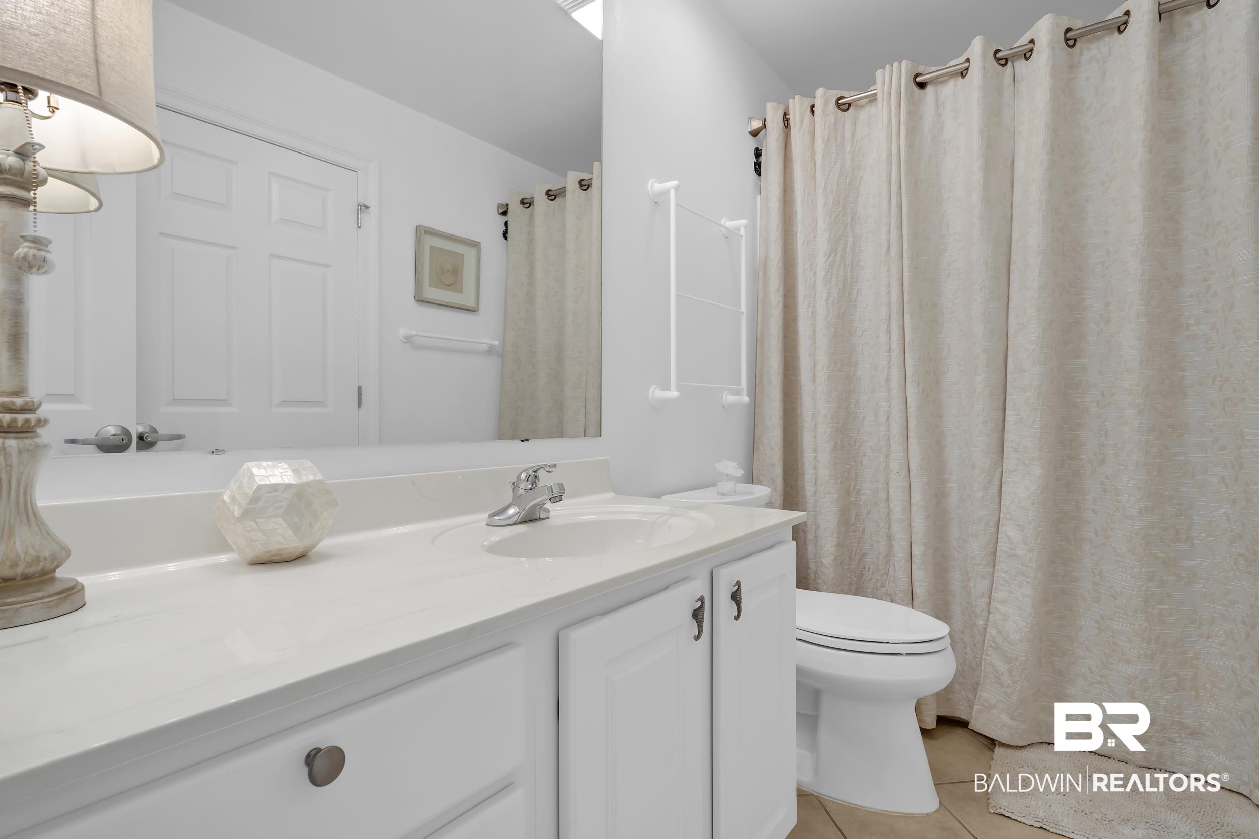27282 Canal Road, Unit 104 Orange Beach, AL 36561 - Photo 45 of 79 Bathroom with curtained shower, vanity, and light tile patterned floors