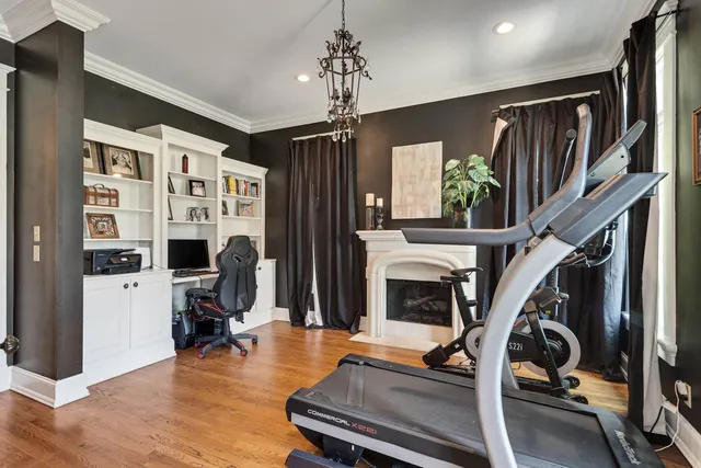 a view of a livingroom with furniture a fireplace chandeliers and a window