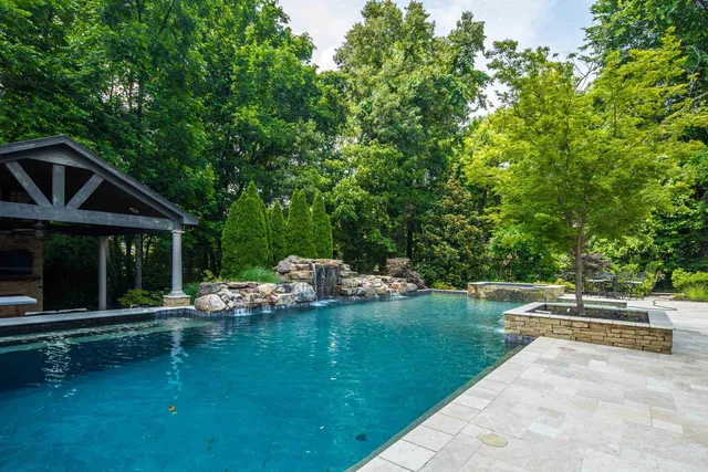 a view of a swimming pool and lounge chairs in the patio