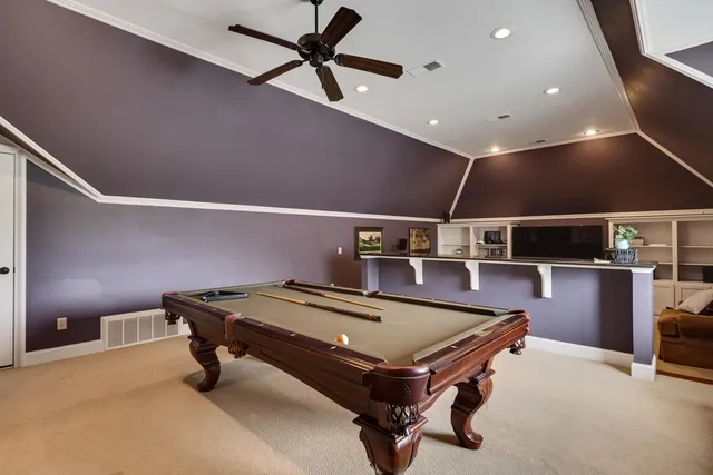 a room with wooden furniture and ceiling fan