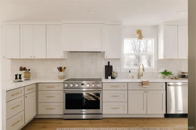 a kitchen with stainless steel appliances a refrigerator a sink a stove top oven a counter space and cabinets