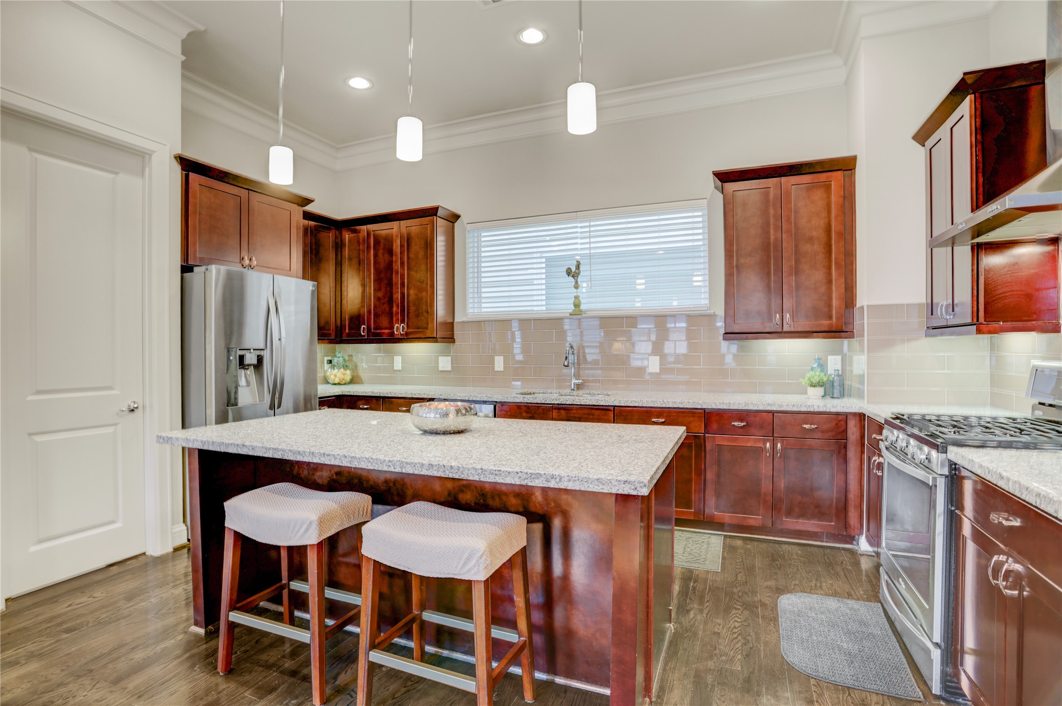 5637 Kiam Street, Unit D Houston, TX 77007 - Photo 3 of 12 a kitchen with granite countertop a table chairs microwave and cabinets