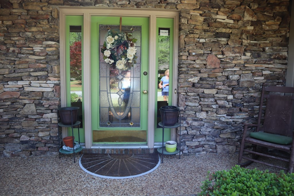 7208 West Wynfield Loop Midland, GA 31820 - Photo 2 of 20 a view of a brick house with a potted plant and a bench