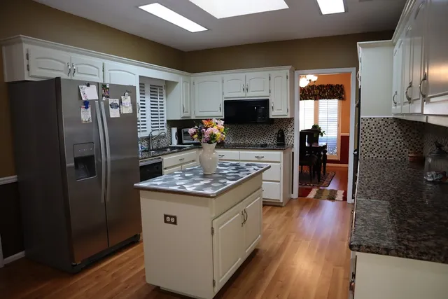a kitchen with a refrigerator and a stove top oven