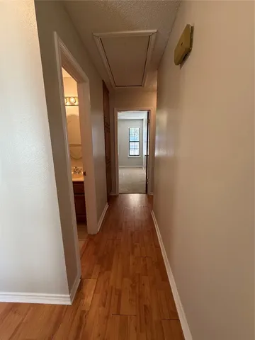 a view of a hallway with wooden floor and staircase