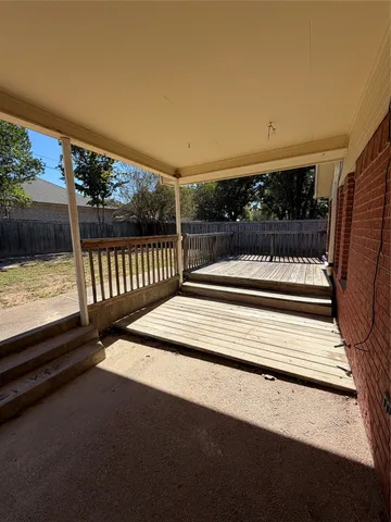 a view of backyard with wooden floor and iron fence