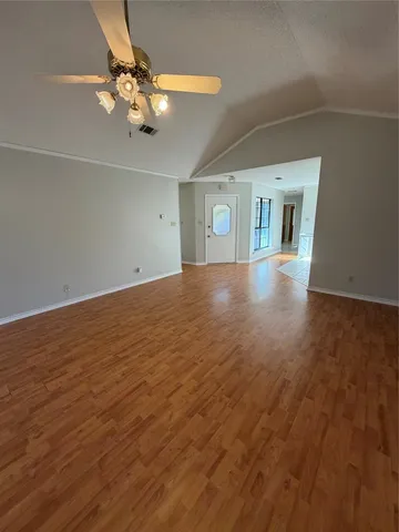 wooden floor in an empty room with a chandelier fan