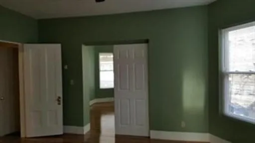 a view of a hallway with windows and wooden floor