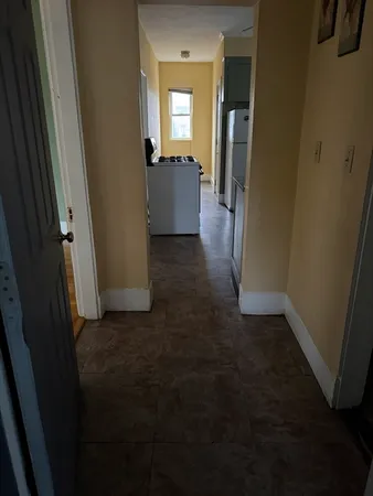 a view of hallway with furniture and wooden floor