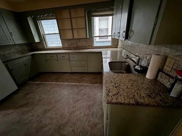 a kitchen with granite countertop a sink and a stove