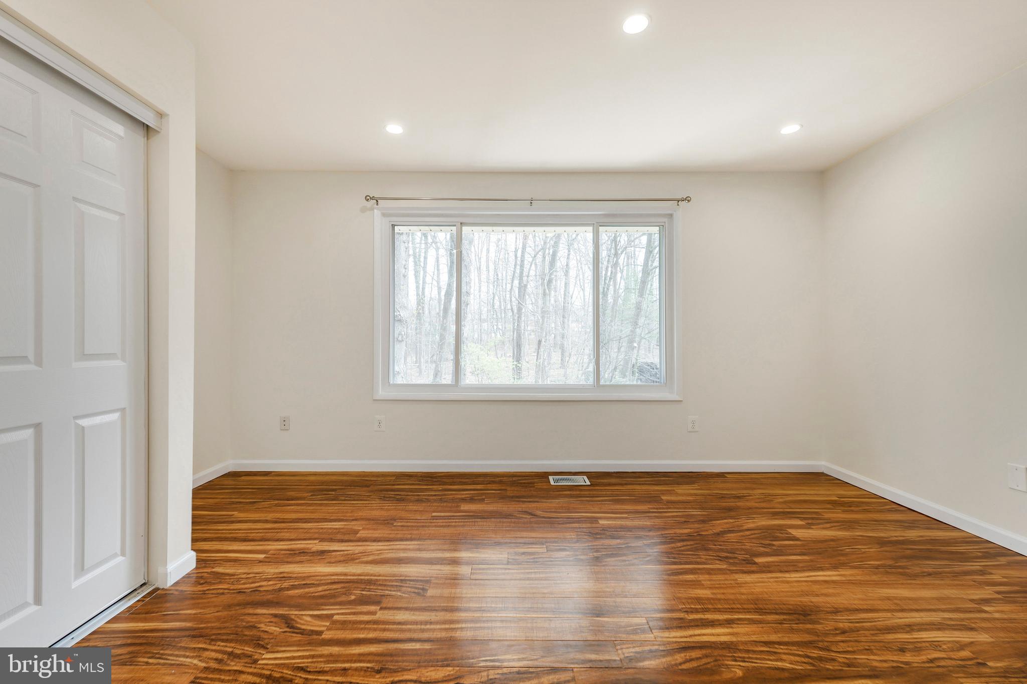 2179 White Cornus Lane Reston, VA 20191 - Photo 14 of 27 a view of an empty room with wooden floor and a window
