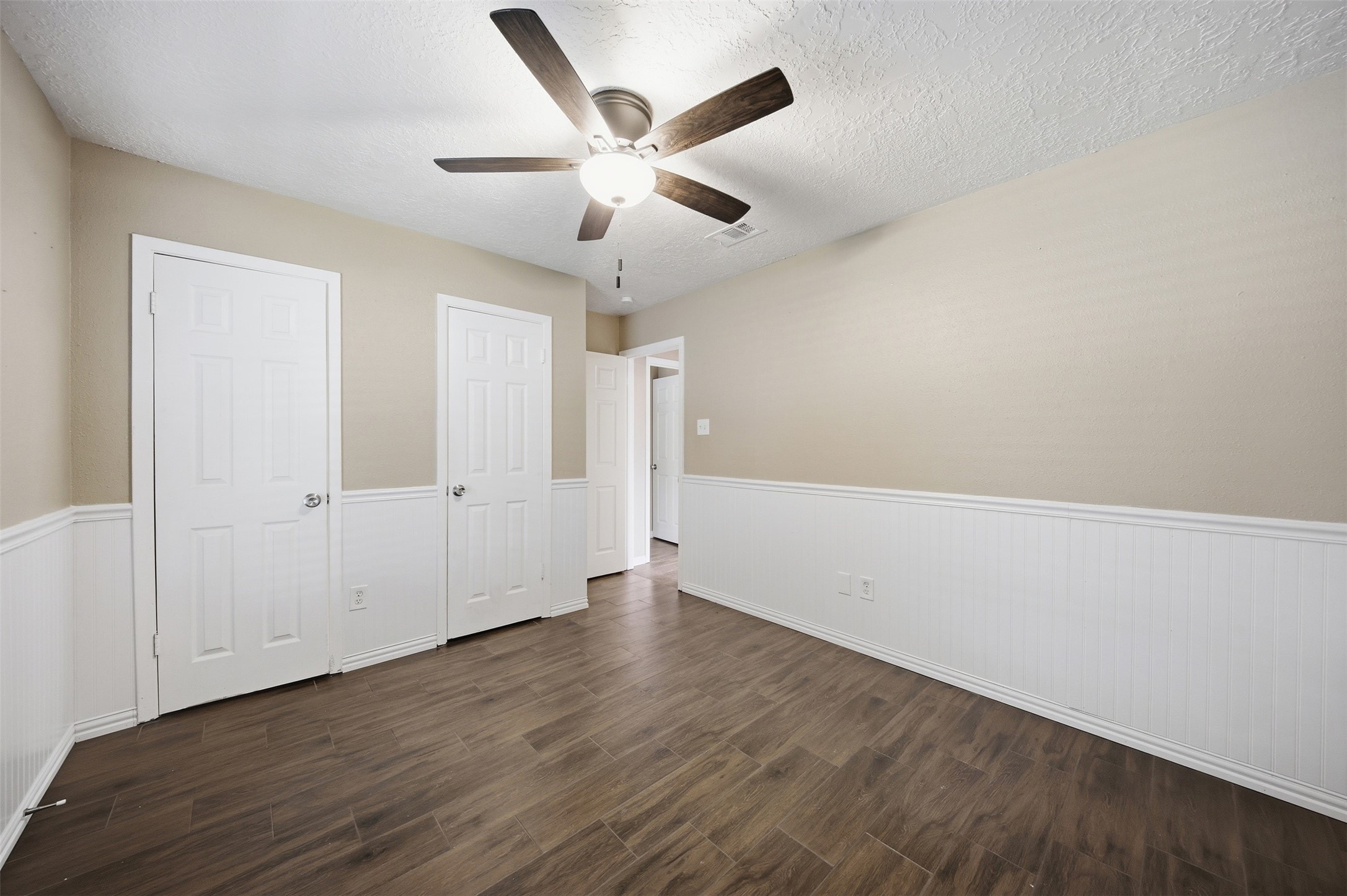 9418 Kilrenny Drive Spring, TX 77379 - Photo 6 of 47 an empty room with wooden floor ceiling fan and windows