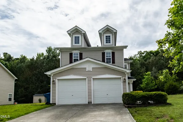 a front view of a house with a yard and garage