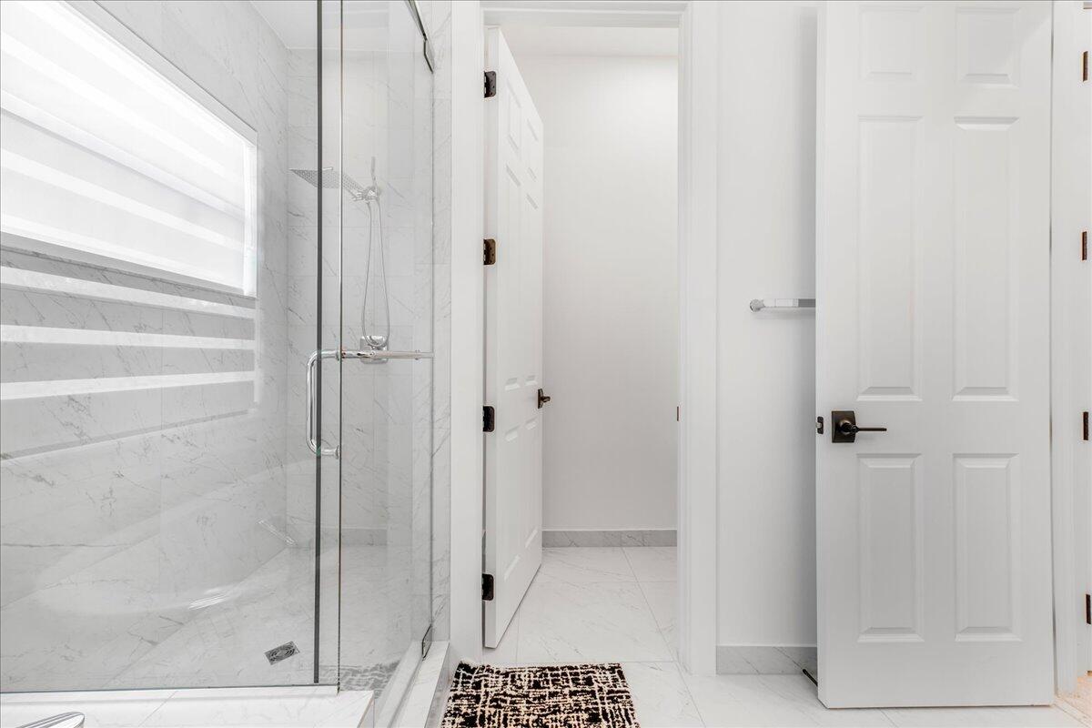 9093 Chauvet Way Boca Raton, FL 33496 - Photo 13 of 31 a bathroom with a glass shower door