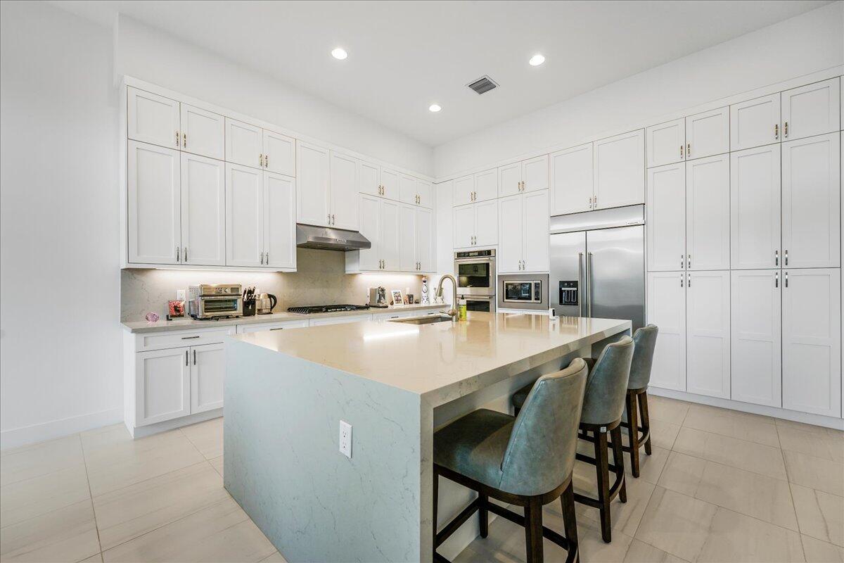 9093 Chauvet Way Boca Raton, FL 33496 - Photo 2 of 31 a kitchen with stainless steel appliances granite countertop a table chairs sink and cabinets