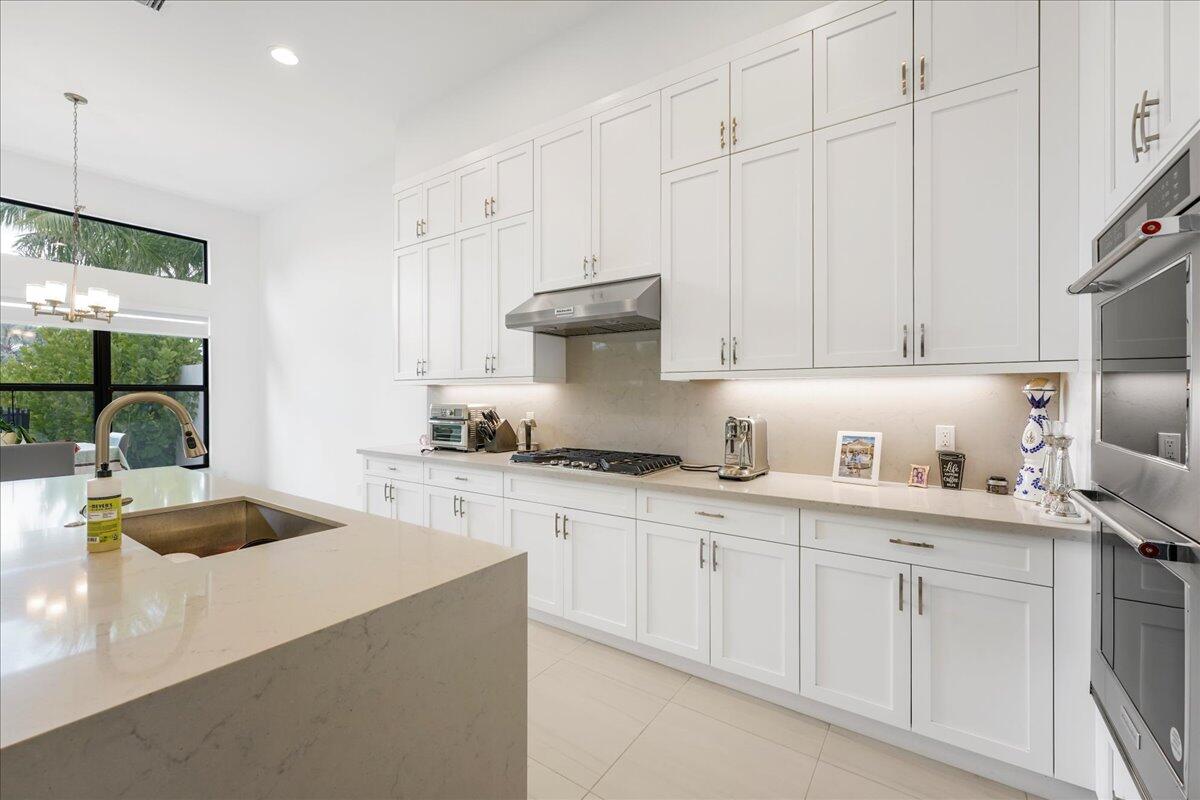 9093 Chauvet Way Boca Raton, FL 33496 - Photo 3 of 31 a kitchen with granite countertop a sink a stove and cabinets