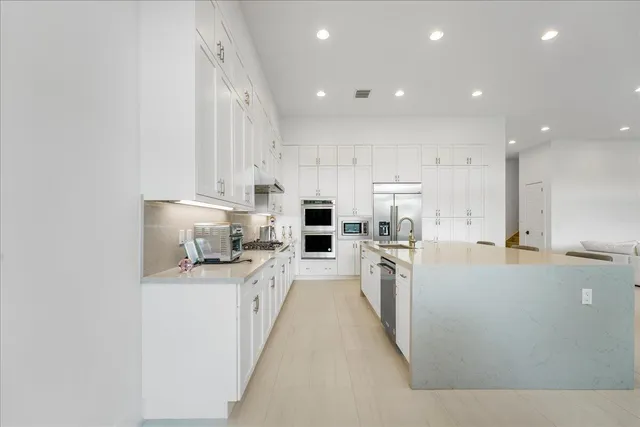 a large kitchen with stainless steel appliances lots of counter top space