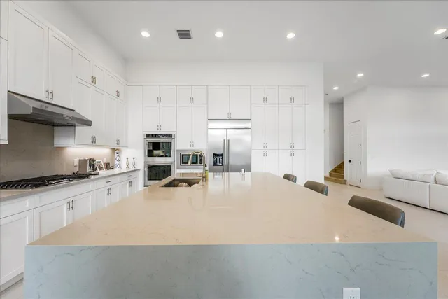 a kitchen with stainless steel appliances granite countertop a sink a stove and a refrigerator