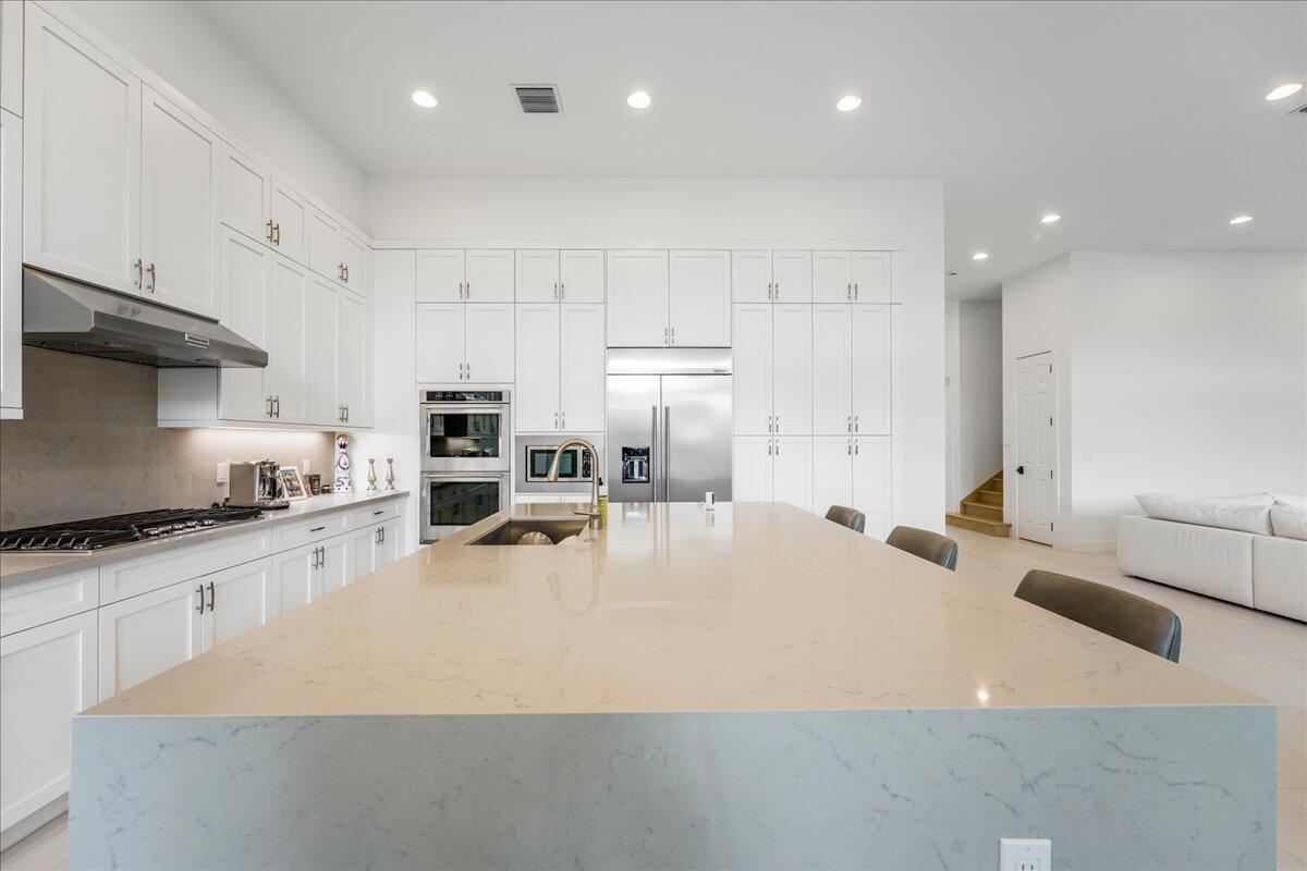9093 Chauvet Way Boca Raton, FL 33496 - Photo 5 of 31 a kitchen with stainless steel appliances granite countertop a sink a stove and a refrigerator