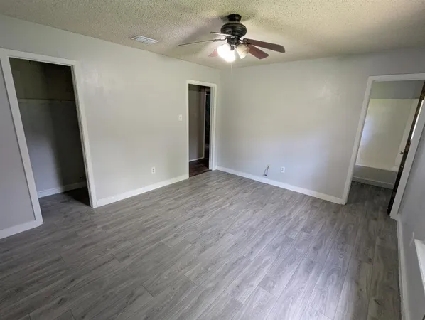 a view of room with wooden floor and ceiling fan