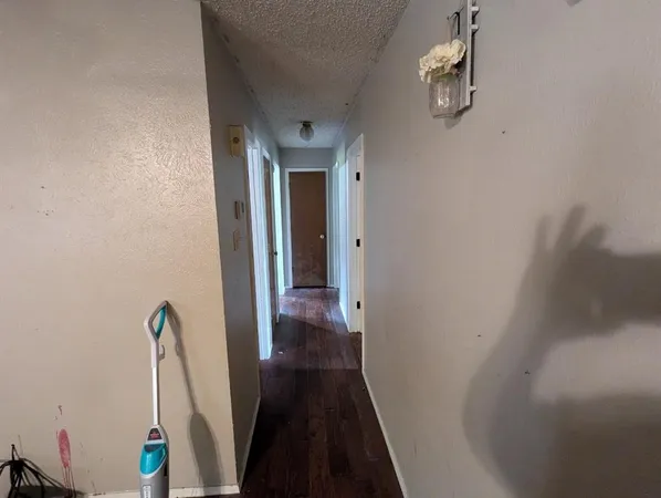 a view of a hallway with wooden floor and stairs