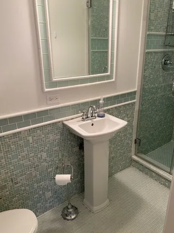 a bathroom with a sink a toilet and mirror