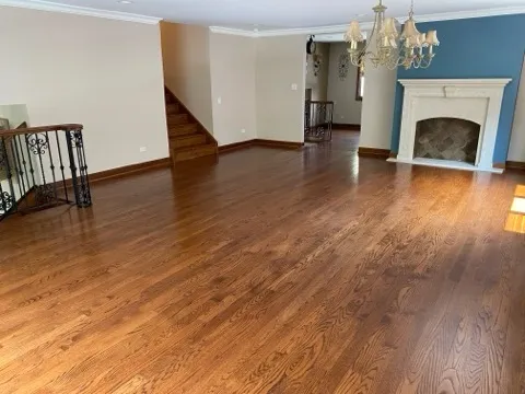 a view of a livingroom with wooden floor and a fireplace