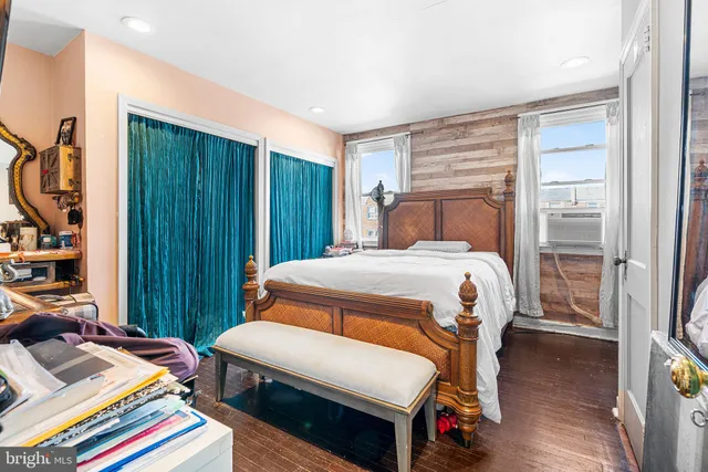 a bedroom with a bed closet and a bookshelf with wooden floor