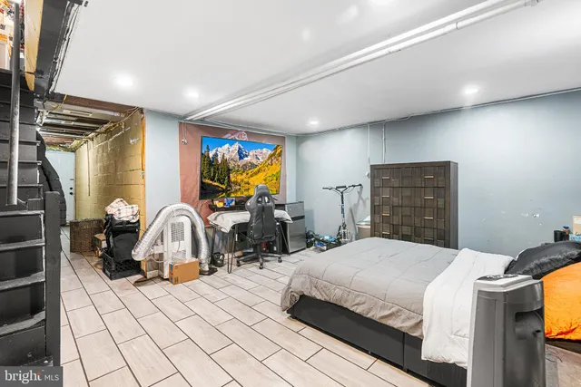 a bedroom with a bed a couch and a flat screen tv